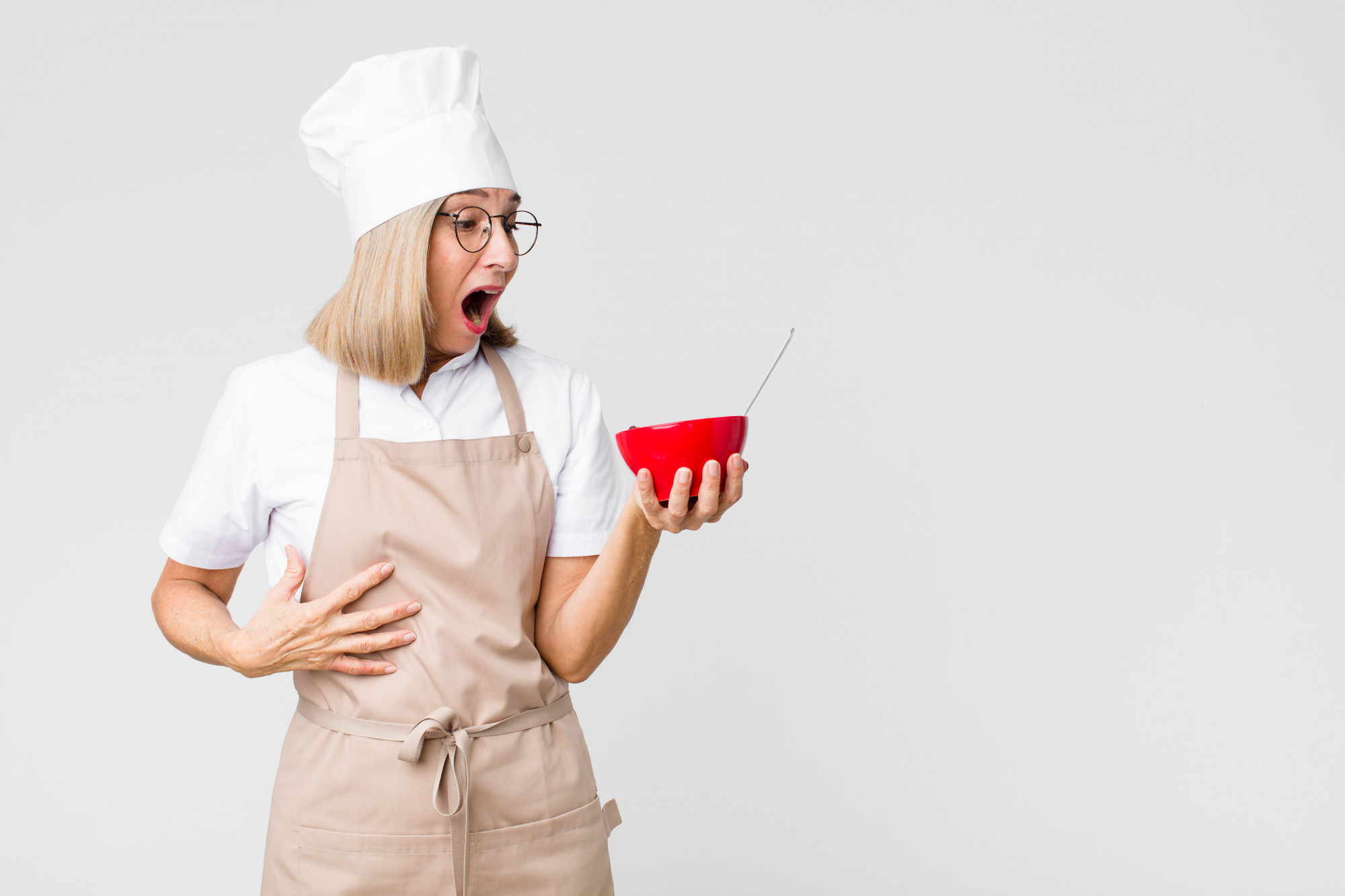 Student tasting sauce in kitchen